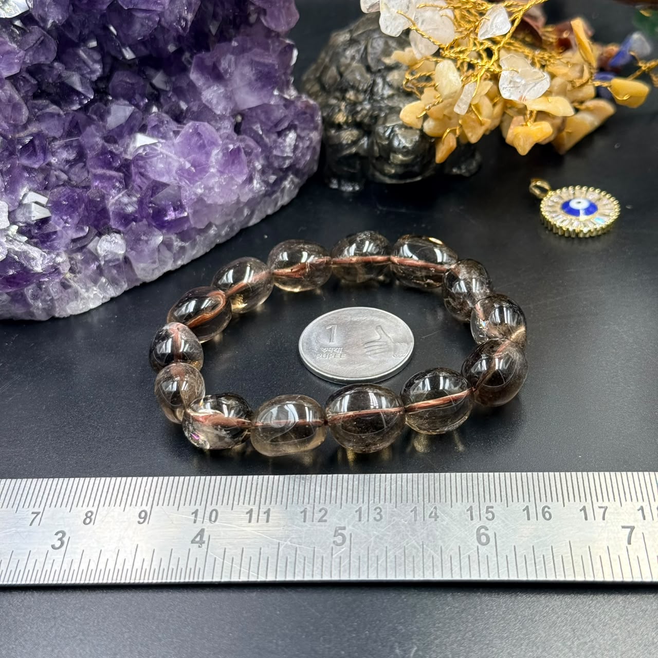 Smoky quartz tumble bead bracelet with copper-thread detail on dark tabletop