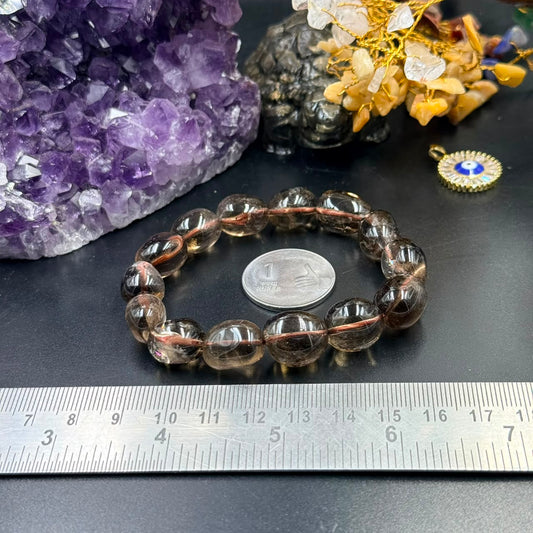 Smoky quartz tumble bead bracelet with copper-thread detail on dark tabletop