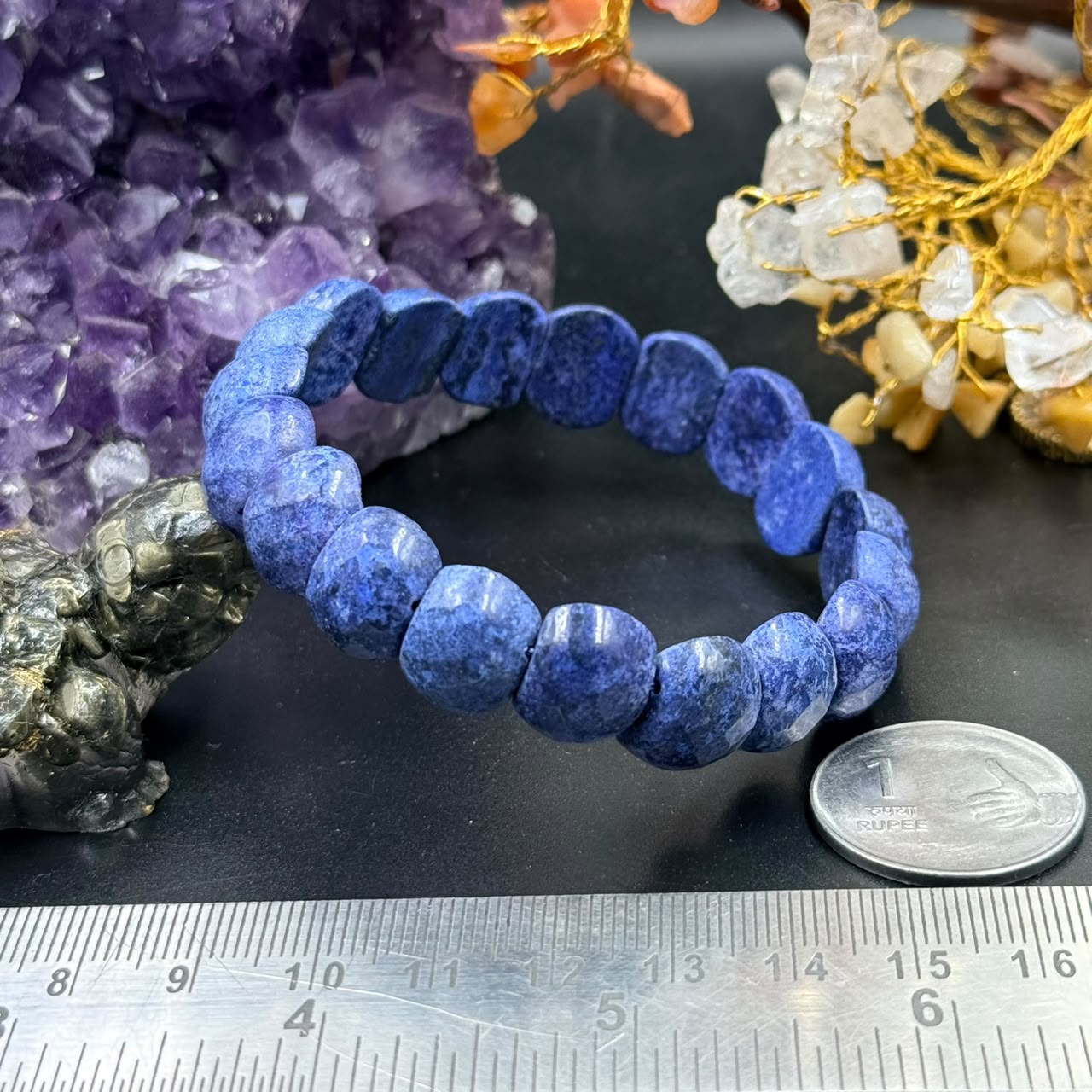 Sodalite oval faceted bead bracelet with blue gemstone beads on dark surface
