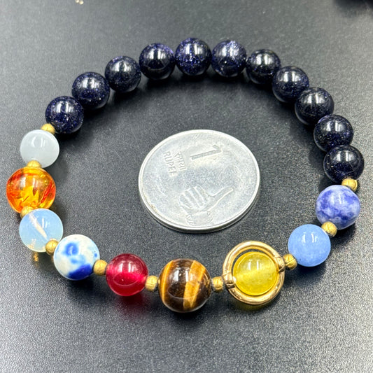 Solar system beaded bracelet with dark blue starry beads and colorful charm beads