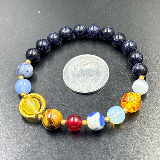 Close-up of solar system bracelet with dark blue beads and colorful planetary accent beads