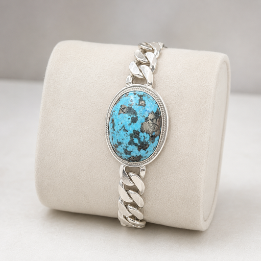 925 sterling silver large Cuban bracelet with turquoise oval matrix stone shown on beige display