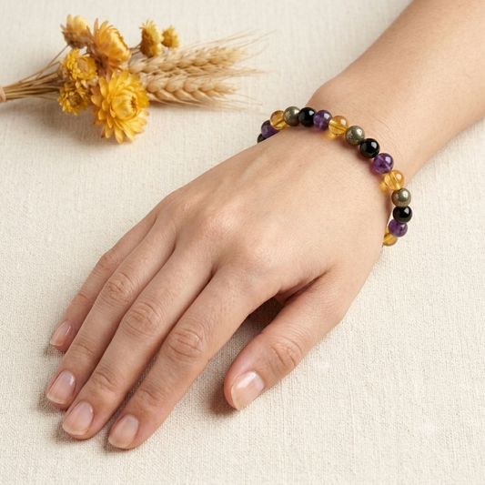 Success & Protection Bracelet on wrist with purple amethyst and black beads and gold-toned citrine accents
