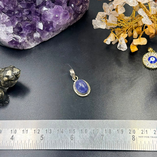 Oval blue tanzanite-style gemstone locket pendant in 925 silver with bail on a ruler