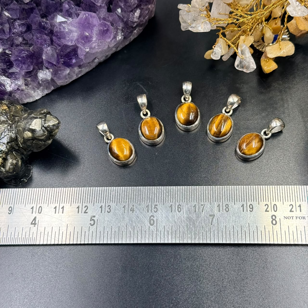 Tiger eye 925 silver locket charm with tiger eye cabochon on dark background