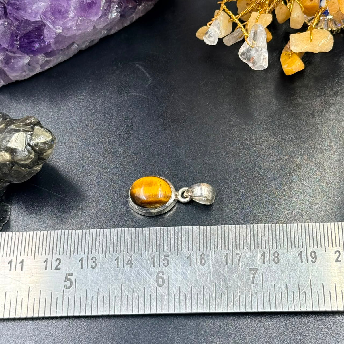 Tiger eye 925 silver locket pendant with tiger eye cabochon and silver bail on scale