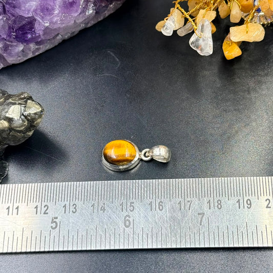 Tiger eye 925 silver locket pendant with tiger eye cabochon and silver bail on scale