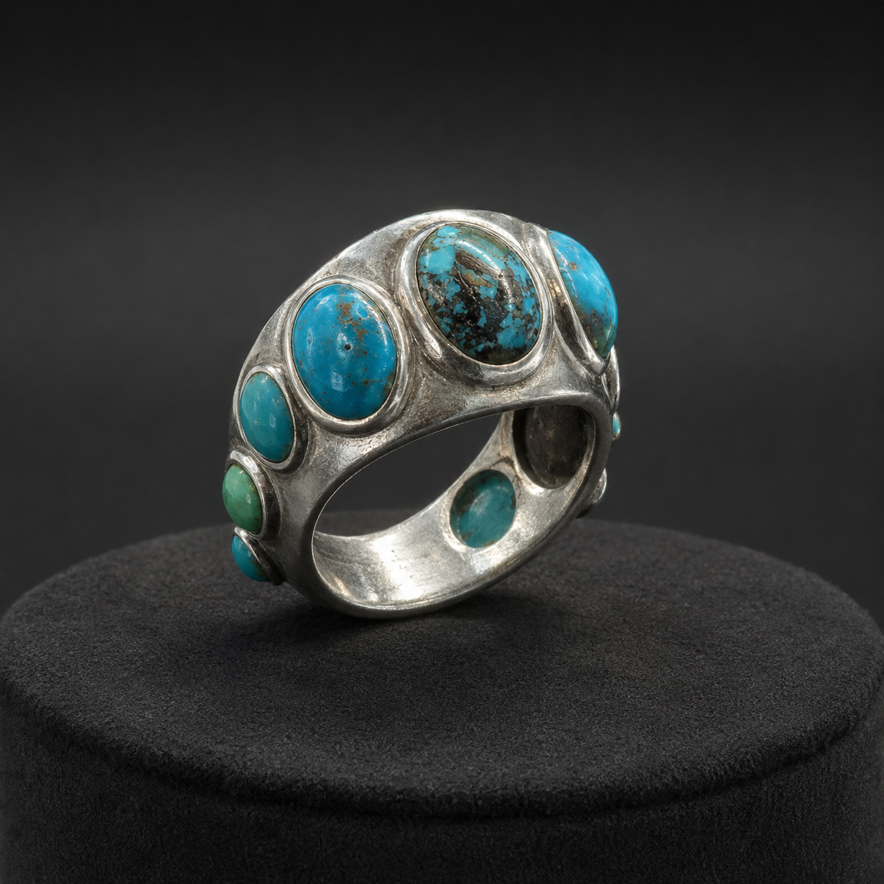 Turquoise multi-stone band ring side view with oval turquoise stones on dark display