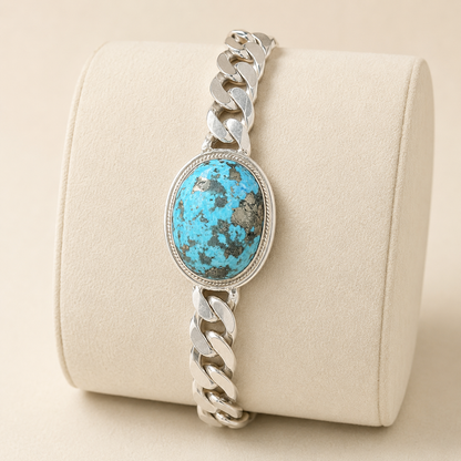 Unisex large turquoise oval stone Cuban link bracelet in 925 sterling silver on beige display