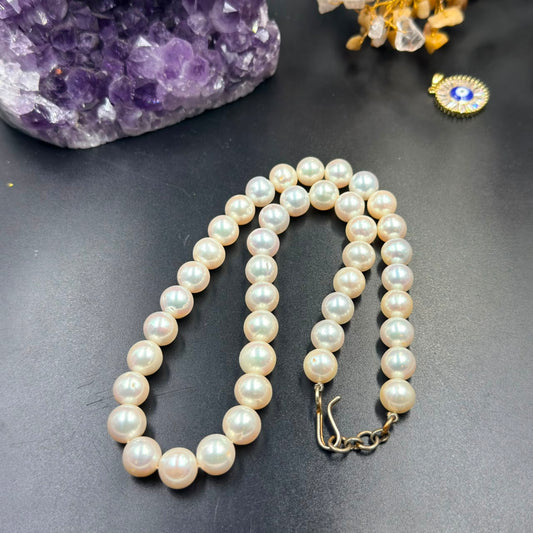 White pearl single-strand mala necklace with large round beads and gold-tone clasp