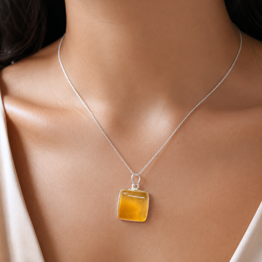 Yellow onyx pendant worn on a fine silver chain necklace against skin